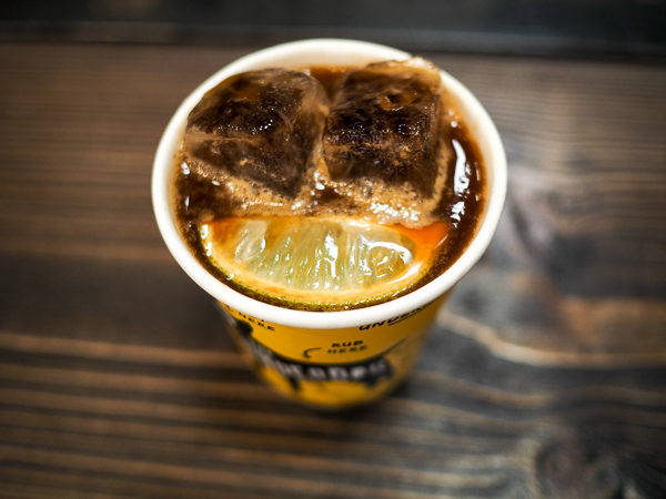 Image shows a cup of Underdog Project's Famous Iced Coffee Tonic - Espresso Over Ice, Topped with Tonic and a Fresh Lime Wedge