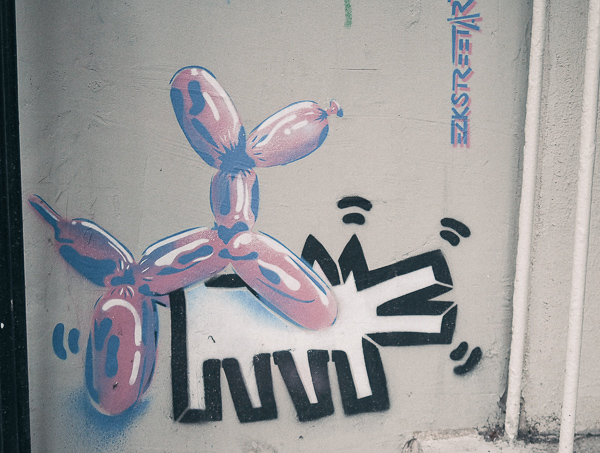 Paris Street Art - showing Jeff Koons balloon animal dog mounting a Keith Haring radiant child dog from behind by artist Eric Ze King a.k.a. EZK